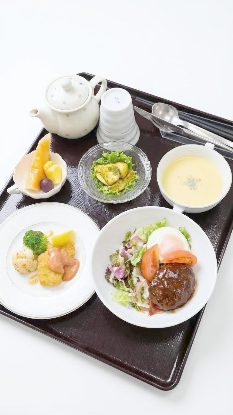 煮込みハンバーグと温泉卵のサラダを添えた洋食の献立